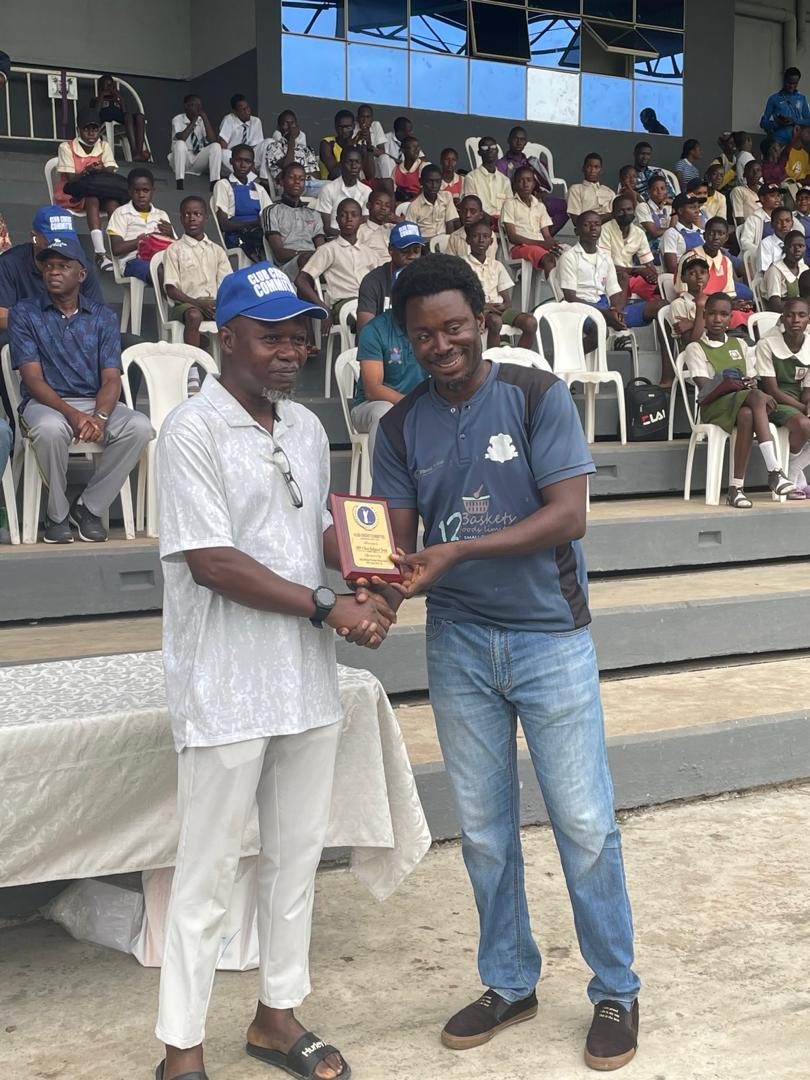 An award being presented to a club representative in front of a seated crowd