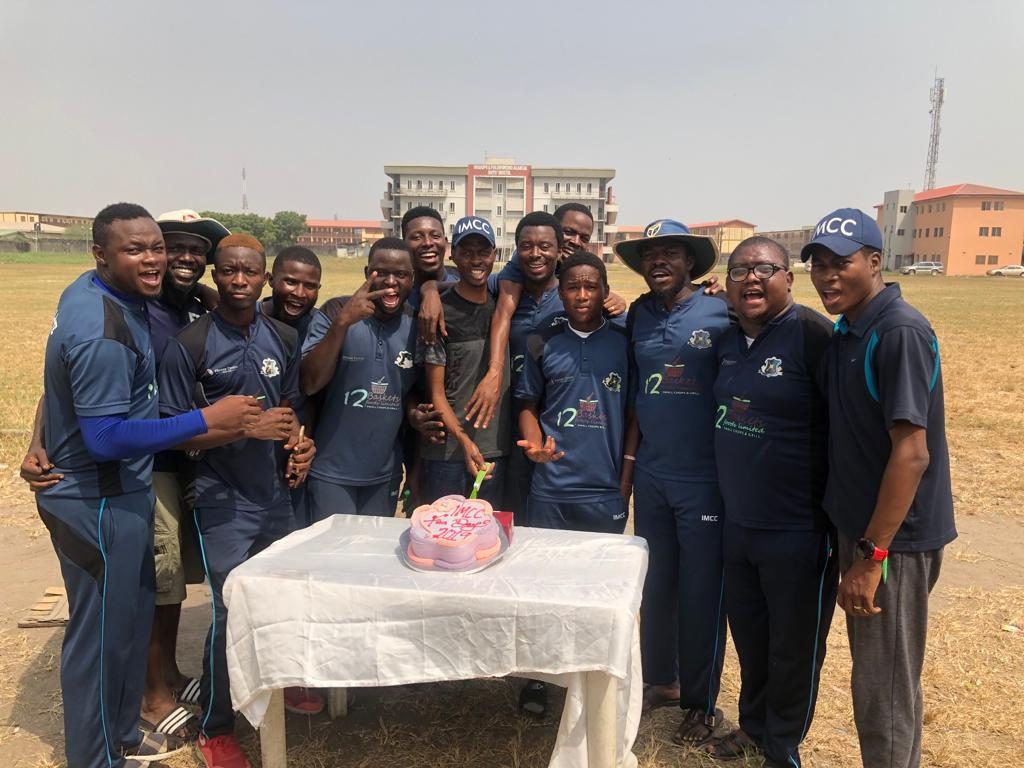 Club members gathered around a cake at the ground